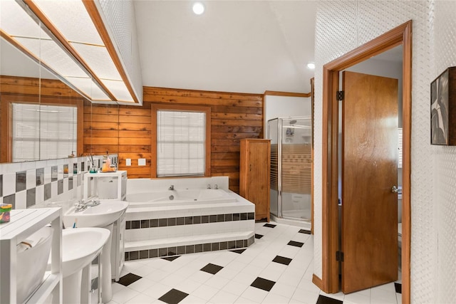 bathroom featuring tile patterned floors, wooden walls, double sink, and plus walk in shower