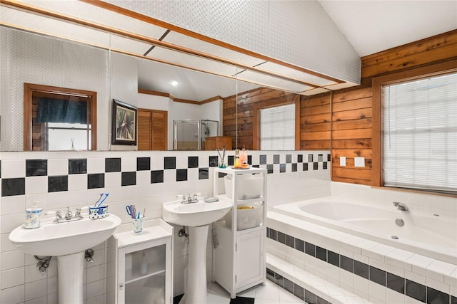 bathroom with lofted ceiling, sink, plus walk in shower, and tile walls