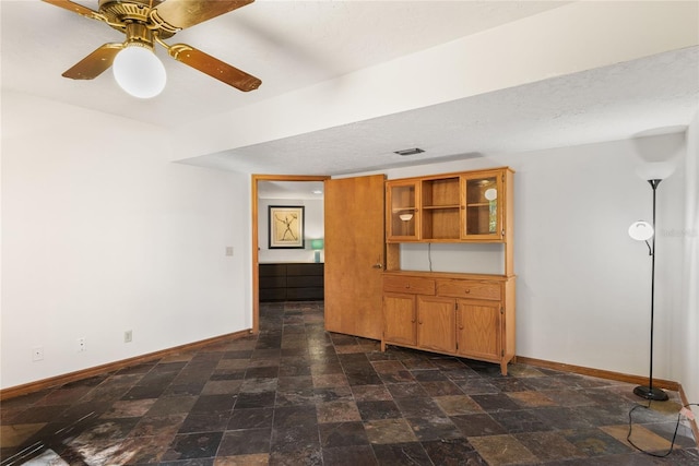 unfurnished living room featuring a textured ceiling and ceiling fan