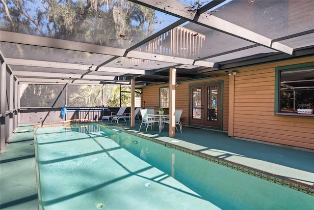 view of pool with french doors, a patio, and a lanai