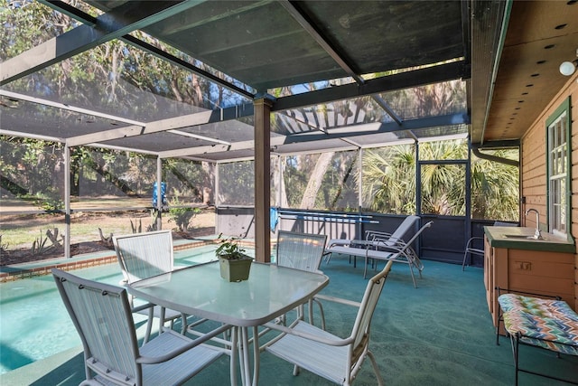 view of patio featuring glass enclosure and sink