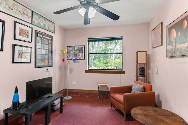 sitting room featuring carpet, a textured ceiling, and ceiling fan