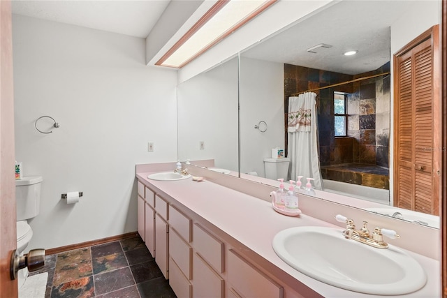 bathroom featuring vanity, toilet, and curtained shower