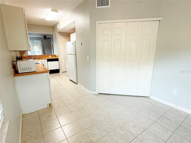 kitchen with ceiling fan, sink, wood counters, a textured ceiling, and white appliances