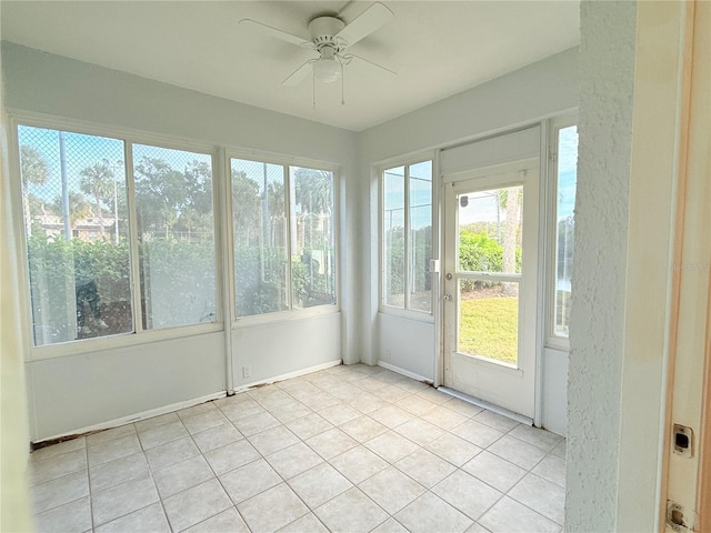 unfurnished sunroom with ceiling fan