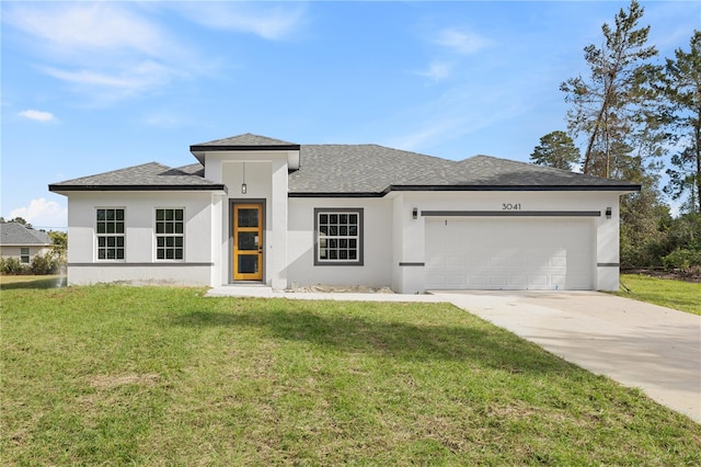 view of front of home with a front yard and a garage