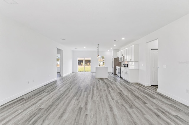 unfurnished living room with sink and light wood-type flooring