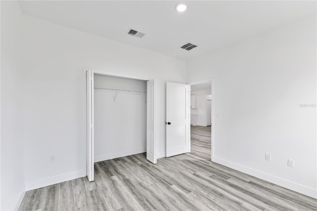 unfurnished bedroom featuring a closet and light wood-type flooring