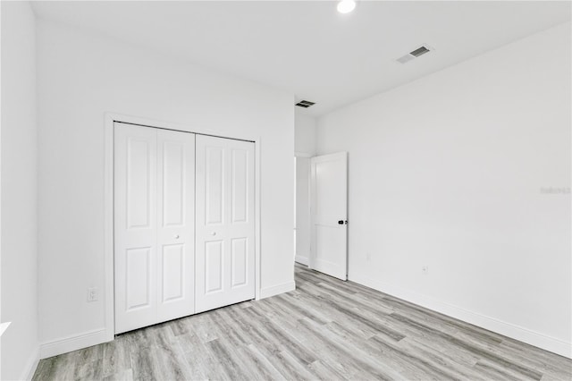 unfurnished bedroom with a closet and light hardwood / wood-style floors