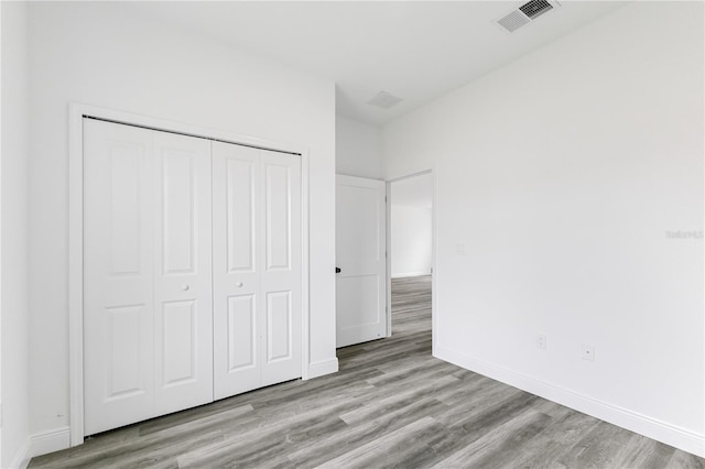 unfurnished bedroom featuring light hardwood / wood-style floors and a closet