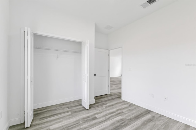 unfurnished bedroom featuring a closet and light hardwood / wood-style floors