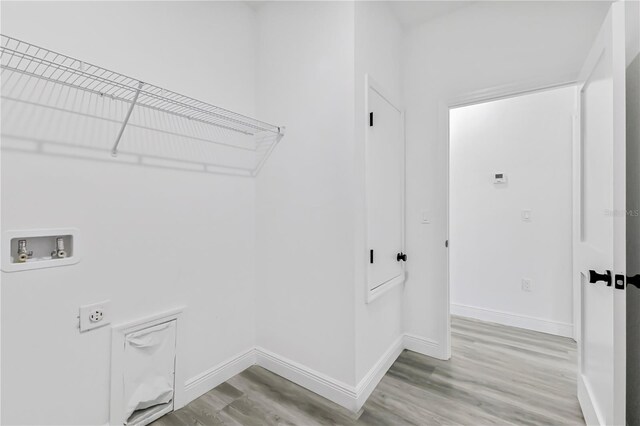 laundry area with hookup for an electric dryer, hardwood / wood-style floors, and washer hookup