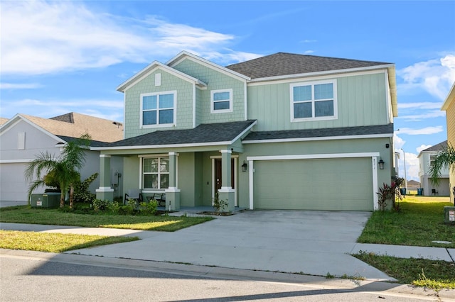 view of front of property featuring driveway, a shingled roof, an attached garage, board and batten siding, and a front yard