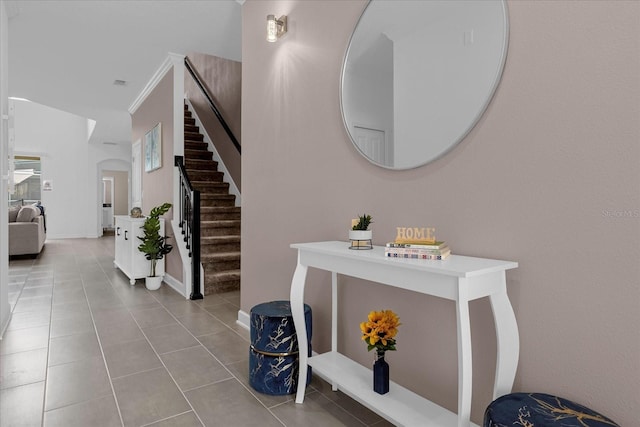 entryway featuring crown molding and light tile patterned flooring