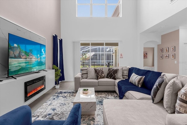 living room featuring a towering ceiling and ornamental molding