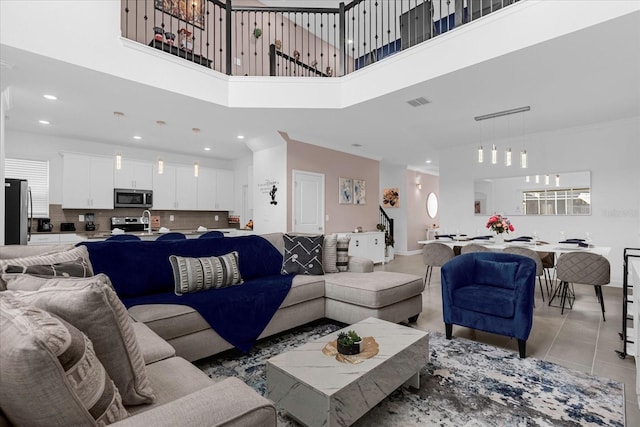 tiled living room with sink and a high ceiling