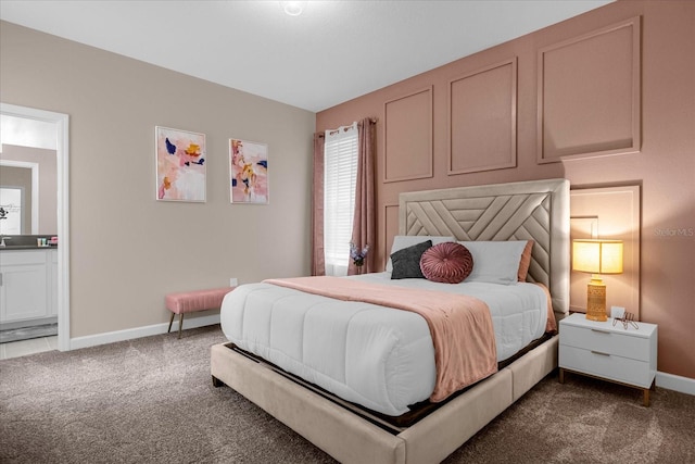 bedroom featuring dark colored carpet and ensuite bath