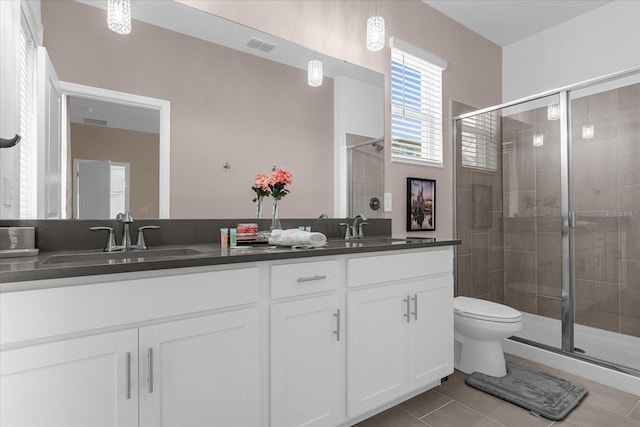 bathroom with tile patterned floors, vanity, toilet, and an enclosed shower