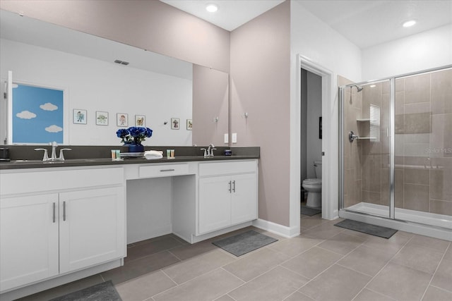 bathroom with tile patterned flooring, vanity, toilet, and walk in shower