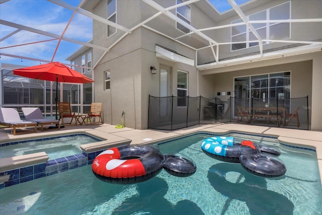 view of pool with glass enclosure, an in ground hot tub, and a patio