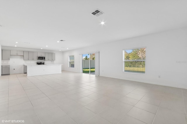 unfurnished living room with plenty of natural light and light tile patterned floors