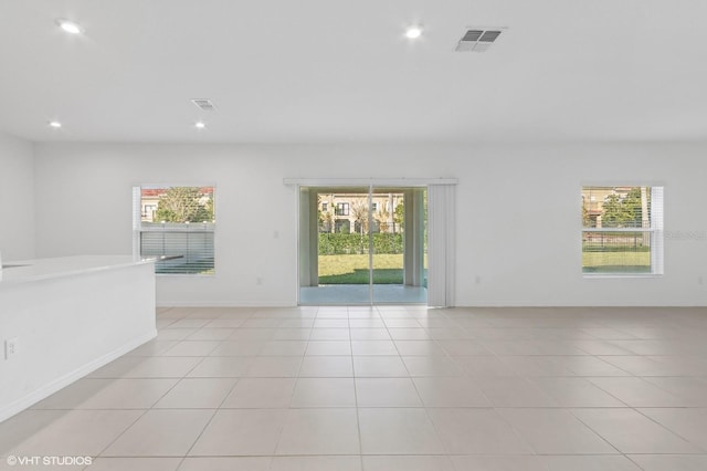 tiled spare room with a healthy amount of sunlight