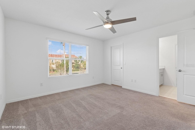 unfurnished bedroom featuring connected bathroom, ceiling fan, and light colored carpet