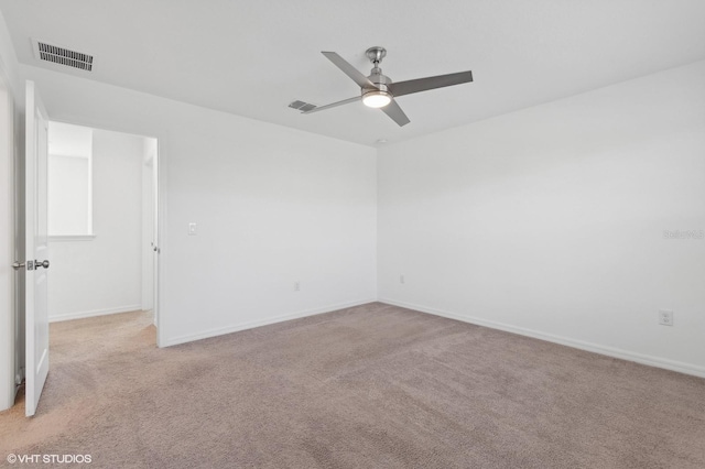 spare room with light colored carpet and ceiling fan