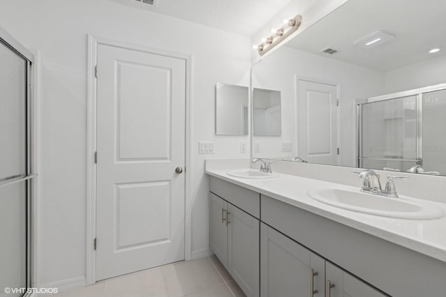 bathroom featuring tile patterned flooring, vanity, and an enclosed shower