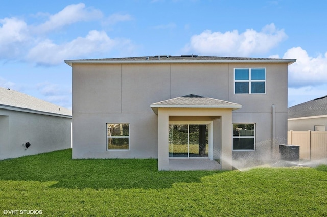 rear view of house with a yard and central AC unit