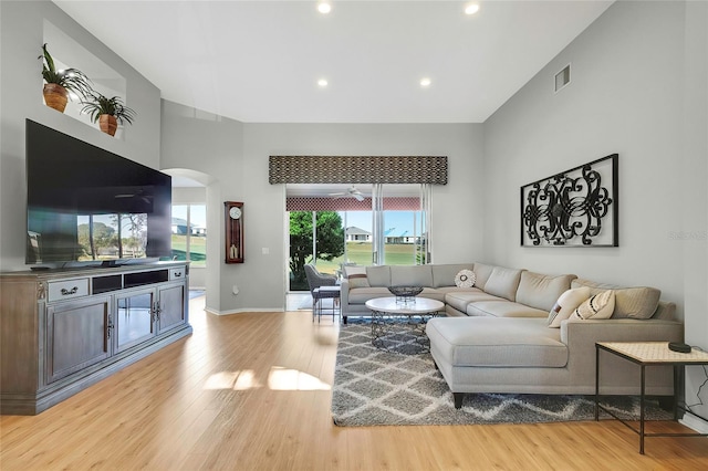 living room with a high ceiling and light hardwood / wood-style flooring