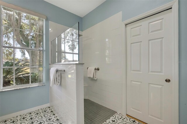 bathroom with tile patterned floors, plenty of natural light, and tiled shower