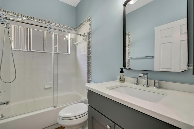 full bathroom with vanity, tiled shower / bath combo, and toilet