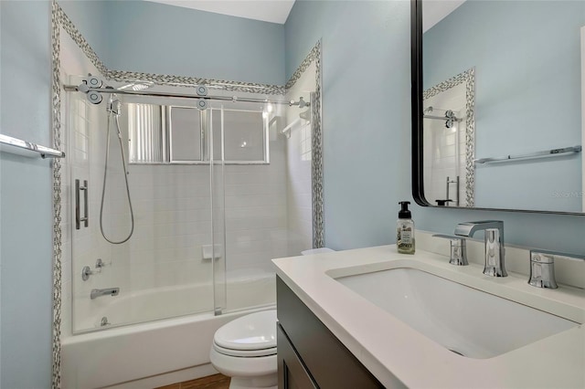 full bathroom featuring vanity, toilet, and shower / bath combination with glass door