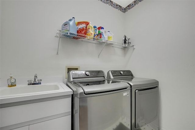 laundry area with separate washer and dryer and sink