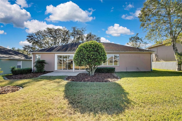 back of property with a lawn and a patio area