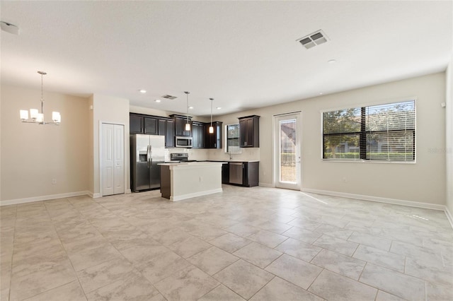 kitchen featuring a center island, an inviting chandelier, decorative light fixtures, and appliances with stainless steel finishes