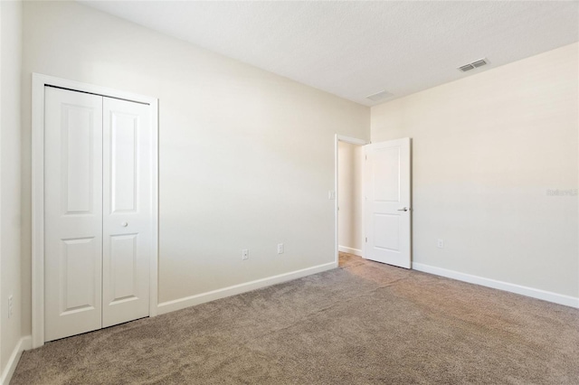 unfurnished bedroom featuring carpet flooring and a closet