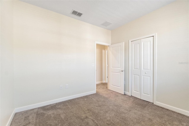 unfurnished bedroom featuring carpet flooring and a closet