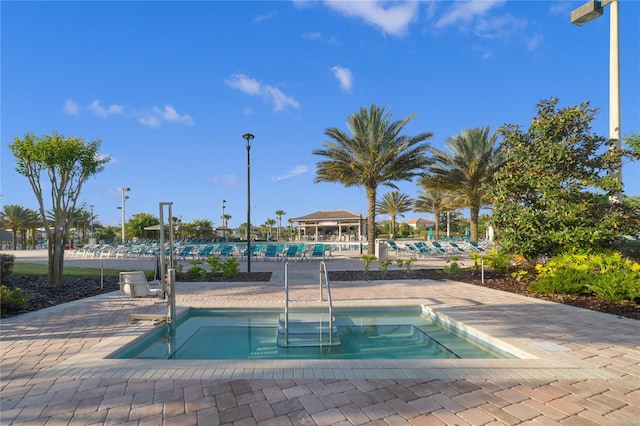 view of swimming pool featuring a community hot tub and a patio