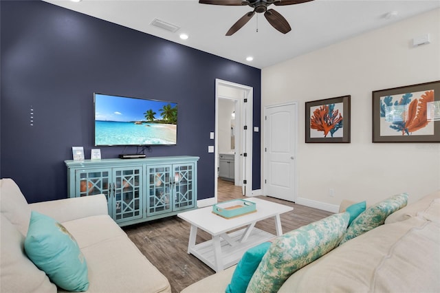 living room featuring ceiling fan and dark wood-type flooring