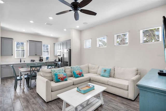 living room featuring hardwood / wood-style floors, sink, plenty of natural light, and ceiling fan