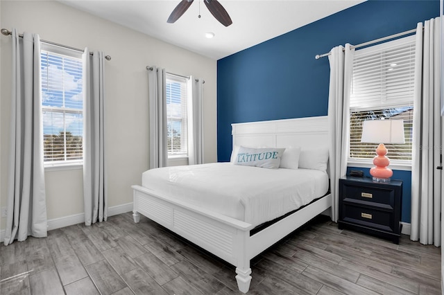 bedroom with multiple windows, hardwood / wood-style flooring, and ceiling fan