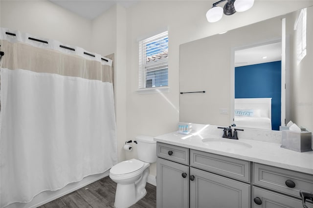 full bathroom with vanity, hardwood / wood-style flooring, toilet, and shower / bath combo with shower curtain