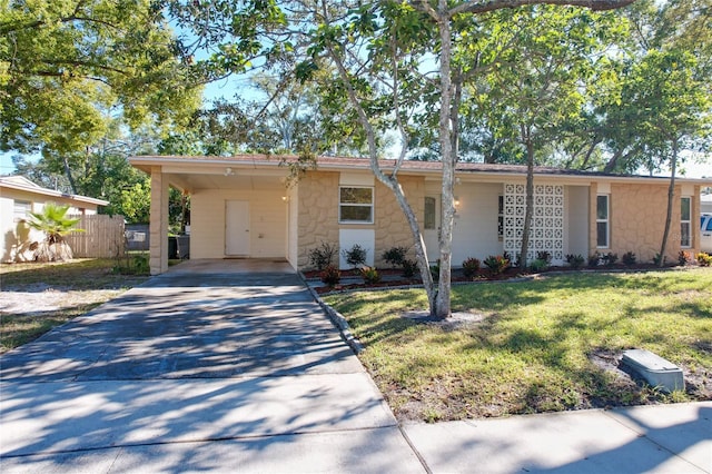 ranch-style house featuring a front lawn and a carport