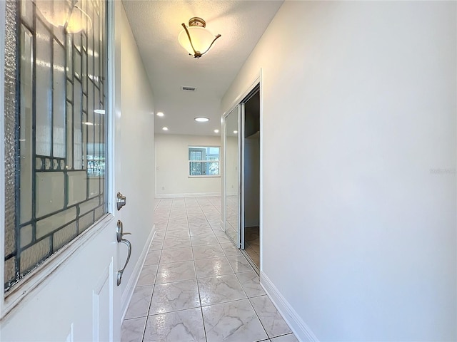 hall with a textured ceiling