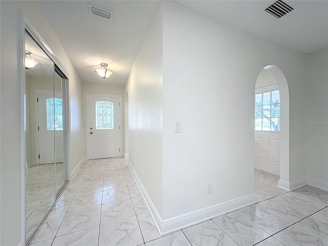 doorway to outside with a textured ceiling