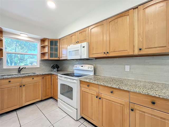 kitchen with sink, light stone counters, backsplash, white appliances, and light tile patterned floors