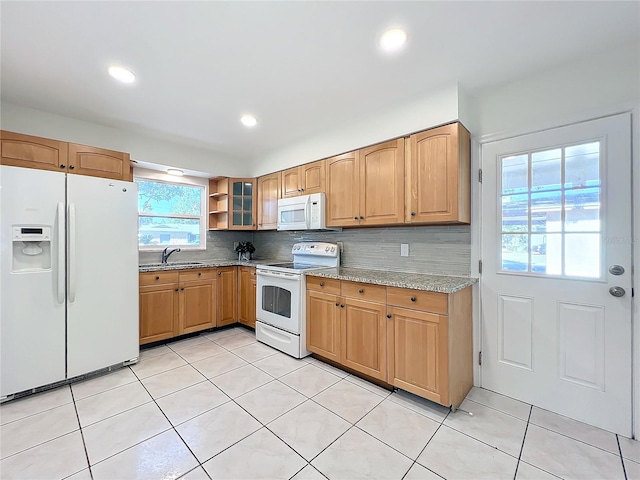 kitchen with white appliances, sink, light tile patterned floors, and tasteful backsplash