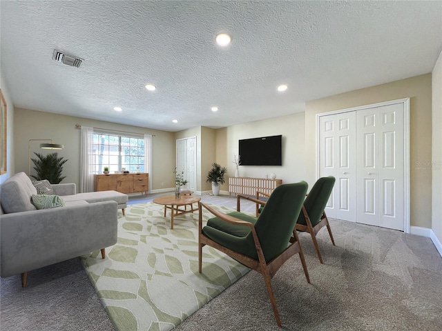 living room featuring carpet floors and a textured ceiling